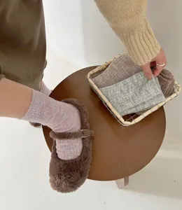 Detailed view of cozy wool socks and warm fuzzy shoes, soft knit texture for cold winter days.