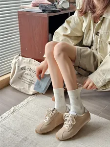 Detailed shot of women mid tube star pattern socks paired with casual sneakers for daily wear.