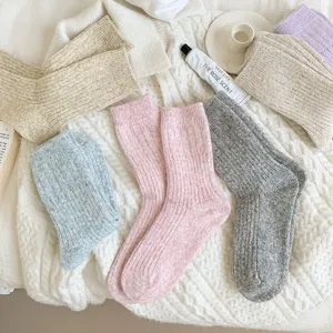 Detailed flat lay shot of cozy knitted wool blend socks in multiple warm winter colors.
