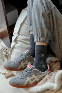 Detailed view of grey ribbed socks with star embroidery paired with casual sneakers.