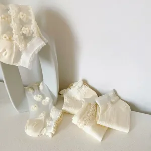 Close-up detail of sweet Japanese style lace crystal short socks with cute floral patterns.