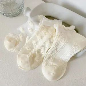 Close-up of white lace mesh short socks with sweet floral embroidery and cute design.