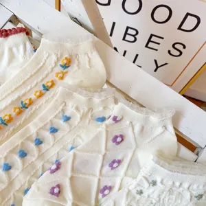 Close-up detail of women cute floral embroidered short socks with delicate lace trim.