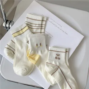 Close-up detail of Japanese style cute embroidered cherry and striped socks for women.