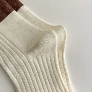 Detailed view of women's ribbed knit socks in cream white and brown, comfortable cotton daily wear.