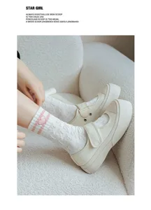 Detailed shot of cute embroidered mid-tube socks with pink stripes and comfy canvas shoes.