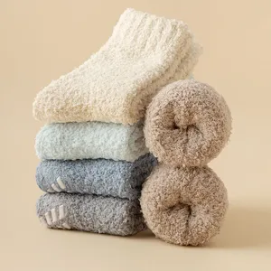 Mucchio di calzini soffici in pile corallo con pallini antiscivolo per inverno caldo.