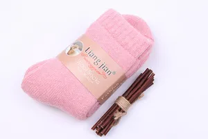 Gros plan de chaussettes en laine rose d'hiver épaisses avec bande et accessoire bois.