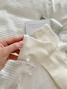 Cream white women socks featuring vertical stripes and thin mid-tube design for spring and summer.