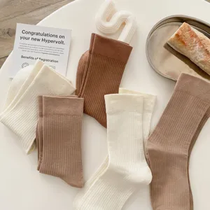 Detailed shot of comfortable cotton ribbed mid-calf socks in white and brown tones.