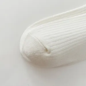 Close-up detail shot of white ribbed knit sock toe, showing soft texture and fine fabric craftsmanship.