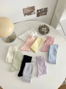 Colorful solid socks detail flat lay, soft pastel cotton daily wear knit hosiery set.