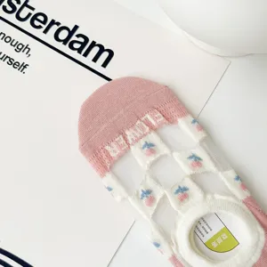 Detail shot of pink and white mesh socks with flower pattern and anti-slip grip.
