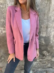 Primo piano dettaglio del blazer da donna in misto lana rosa con collo a risvolto e bottone.