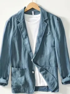 Vista detallada de un blazer casual azul grisáceo con una camiseta blanca dentro.
