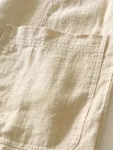 Primer plano del detalle del bolsillo del blazer casual de algodón y lino con textura de tela.