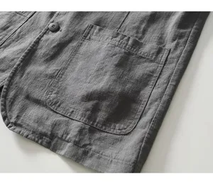 Primer plano del bolsillo de la chaqueta gris de hombre y detalles de tela texturizada.