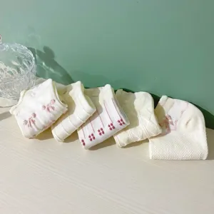 Detail shot of sweet Japanese style women's socks with cute bow and flower patterns.