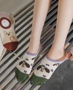 Detail shot of women's low-cut invisible socks featuring cute dog patterns and green toe.