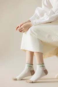 Close-up detail of cute Japanese style women short socks with green stripes and cute print.