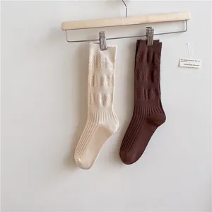 Vista dettagliata di calzini medi da donna in stile giapponese semplice in beige e marrone.