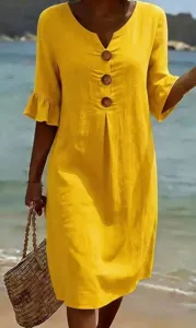 Resort style yellow V-neck midi dress detail, featuring decorative buttons and ruffled sleeves.