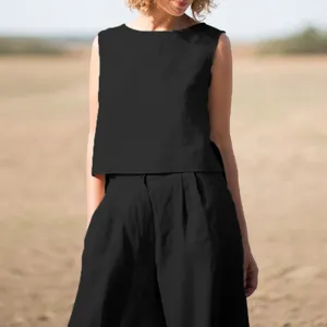 Dettagli del top nero senza maniche e dei comodi pantaloni larghi abbinati in lino.
