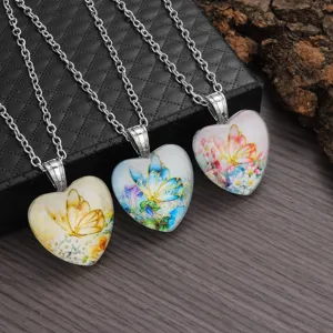 Gedetailleerd overzicht van hart glas hanger kettingen met bloemen vlinder ontwerpen.