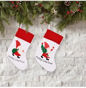 Close-up of Christmas stockings with gnome embroidery, hanging on holiday decorated wall.