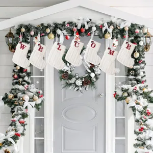 White knitted Christmas stockings with embroidered welcome letters, holiday gift candy bags.
