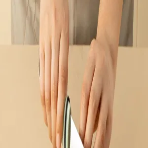 Detail view showcasing hands operating the household kitchen peeler tool during practical use.