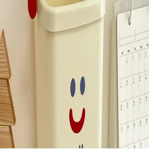 Close-up of the cute mini desktop trash can detail, featuring a lovely smiling face and press ring.