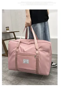 Large capacity pink travel storage duffel bag detail showing front pocket and durable handles.