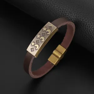 Primo piano del bracciale in pelle PU marrone con metallo bronzo antico inciso e chiusura magnetica.