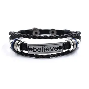 Brazalete de cuero negro trenzado multicapa vintage con placa metálica inspiradora.
