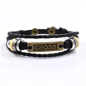 Vista detallada de pulsera de cuero trenzado negro multicapa vintage con placa de bronce.