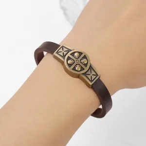 Primo piano del bracciale in pelle da uomo punk retro con decoro in bronzo anticato e teschi.