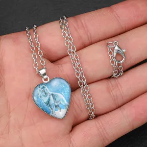Detailed close-up of the silver heart wolf pendant necklace, showing the exquisite glass dome design.
