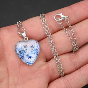 Close up view of the silver heart shaped pendant necklace featuring a beautiful crystal wolf design.