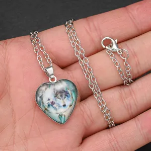 Closeup of a silver heart necklace featuring a detailed wolf totem glass cabochon pendant.