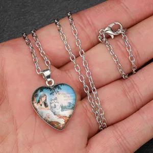Detailed close-up of a silver-tone chain necklace with a heart-shaped glass pendant showing fantasy art.