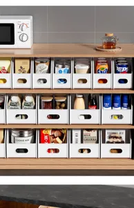 Kitchen storage box detail shot showing plastic organizer basket filled with snacks and bottles.