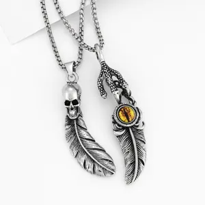 Closeup view of gothic punk skull and evil eye feather pendant necklaces in antique silver.