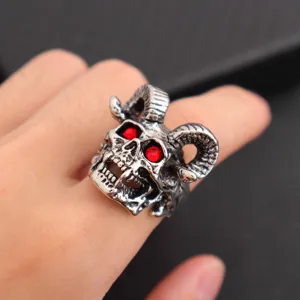 Gedetailleerd aanzicht van punk ram schedel ring met rode zirkon ogen in antieke zilverlook.