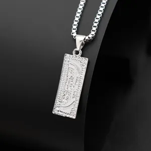 Detailed shot of silver dollar bill pendant necklace, engraved metal tag on box chain.