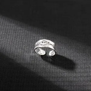 Nahaufnahme des retro unregelmäßigen silbernen Keep Smile Rings mit graviertem Smiley Gesicht.