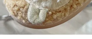 Close-up detail of cozy winter plush cotton slippers with soft fuzzy texture and sole.