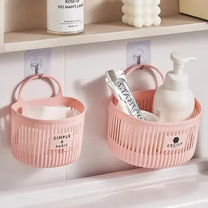 Wall-mounted plastic hanging storage basket for kitchen and bathroom organization, pink color.