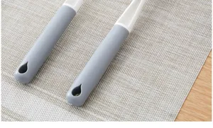 Close-up detail of long cleaning brush handle, ergonomic non-slip grip with hanging hole.
