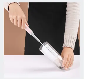 Detailed view showing the long handle cup brush cleaning a glass bottle for kitchen use.